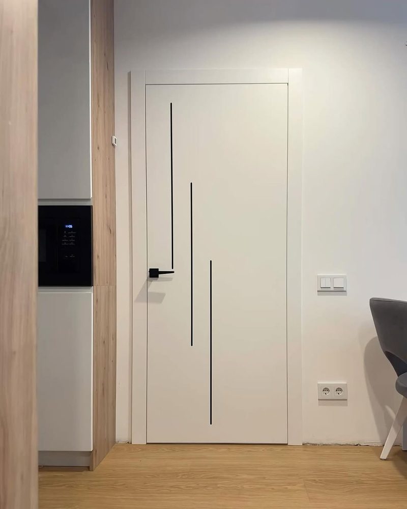 Trio model, üç dikey siyah çizgi detaylı beyaz lake kapı, modern mutfak girişinde